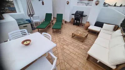 a patio with a table and chairs on a balcony at Casa Salina in Chiclana de la Frontera