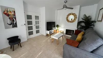 a living room with a couch and a tv at Casa Salina in Chiclana de la Frontera