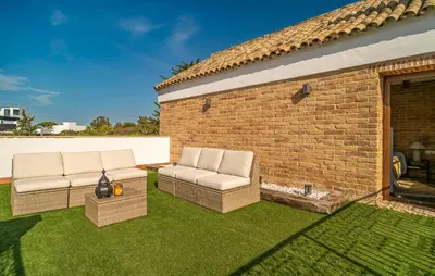 a patio with two chairs and a brick building at Beautiful Home In Conil De La Frontera in Conil de la Frontera