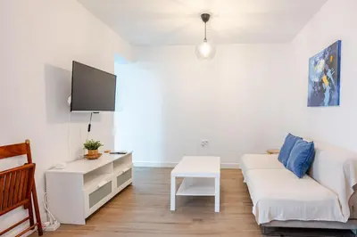 a living room with a white couch and a table at Casa con encanto - Wifi, aire acondicionado in Puerto Real