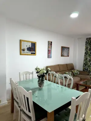 a dining room with a blue table and white chairs at Paraíso Frente al Mar en Cádiz in Cádiz