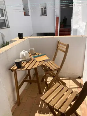 a wooden table and a chair on a balcony at Arcos de la Loba by casitasconencantoes in Medina Sidonia