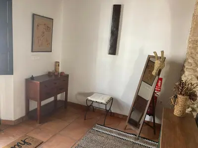 a room with a dresser a mirror and a table at Arcos de la Loba by casitasconencantoes in Medina Sidonia