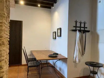a dining room with a wooden table and chairs at Arcos de la Loba by casitasconencantoes in Medina Sidonia