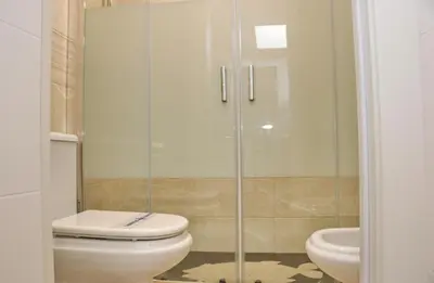 a bathroom with a toilet and a glass shower at Apartamento Dúplex Bahia Sur in San Fernando