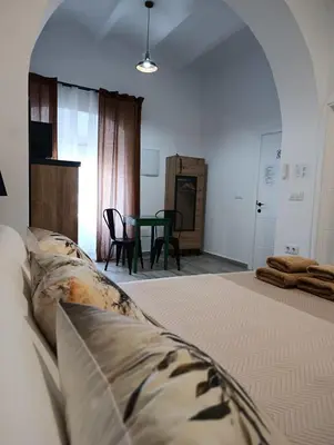 a bedroom with a bed and a table with chairs at Casa Sahar in Arcos de la Frontera