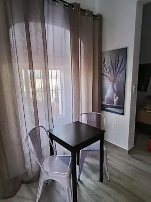 a black table and two chairs in a room with a window at Casa Sahar in Arcos de la Frontera