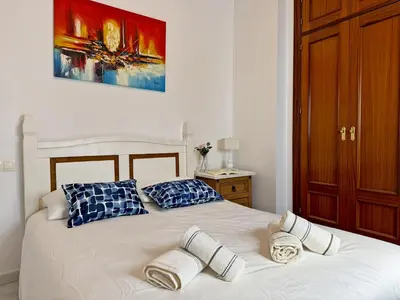 a bedroom with two beds with blue and white pillows at Apartamento Las Palmeras - Ole Solutions in Jerez de la Frontera