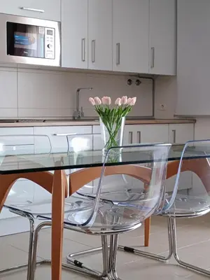 a kitchen with a glass table and a vase of flowers at Balcon mirador de las Salinas in Sanlúcar de Barrameda