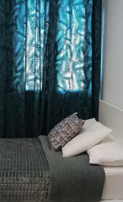 a bedroom with a bed with a curtain and a pillow at Balcon mirador de las Salinas in Sanlúcar de Barrameda
