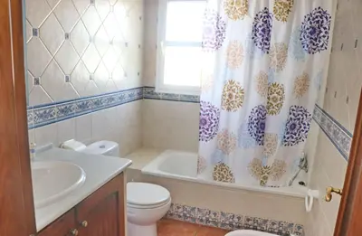 a bathroom with a toilet and a shower curtain at Casa Ana in Conil de la Frontera