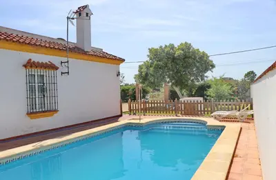 a swimming pool in front of a house at Casa Ana in Conil de la Frontera