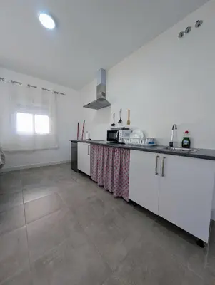 a kitchen with white cabinets and a tile floor at A Jerez Apartamentos in Jerez de la Frontera