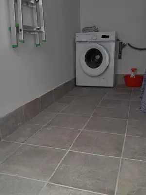 a washing machine in a room with a tile floor at A Jerez Apartamentos in Jerez de la Frontera