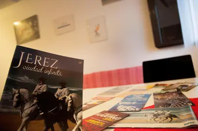 a book sitting on top of a table next to a table with at A Jerez Apartamentos in Jerez de la Frontera