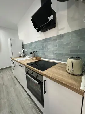 a kitchen with a sink and a stove top oven at Apartamentos playa in Sanlúcar de Barrameda