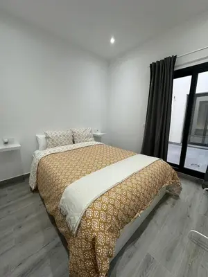a bedroom with a bed and a window at Apartamentos playa in Sanlúcar de Barrameda