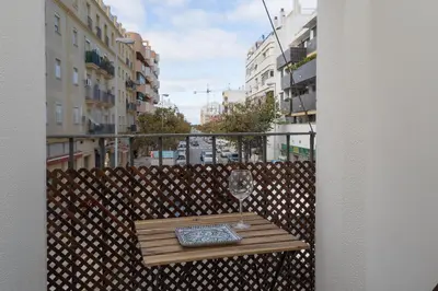 a balcony with a table with a wine glass on it at SibsSanlucar Carril San Diego 2 Coqueto Centrico Terraza in Sanlúcar de Barrameda