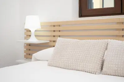a bedroom with a white bed with a lamp at SibsSanlucar Carril San Diego 2 Coqueto Centrico Terraza in Sanlúcar de Barrameda