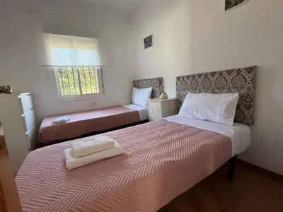 a bedroom with two beds and a window at Doña Violeta con jardin Grupo AC Gestion in Novo Sancti Petri