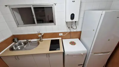 a small kitchen with a sink and a refrigerator at Doña Violeta con jardin Grupo AC Gestion in Novo Sancti Petri