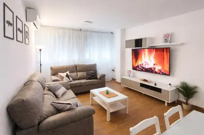 a living room with a couch and a flat screen tv at CITYHOUSE! NUEVO REFORMADO CONFORT WIFI TV65 AC FULL Visco in San Fernando