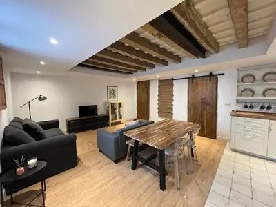 a living room with a wooden table and a kitchen at Loft Abril Grupo AC gestion in Cádiz