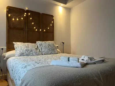 a bedroom with a large bed with a large headboard at Loft Abril Grupo AC gestion in Cádiz