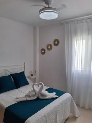 a bedroom with a bed with two towels on it at Apartamento Brisa Salada Center in Sanlúcar de Barrameda