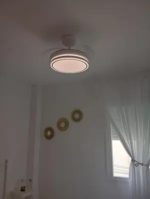 a ceiling with a light and two clocks on the wall at Apartamento Brisa Salada Center in Sanlúcar de Barrameda