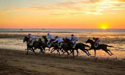a group of people riding horses on the beach at Apartamento Brisa Salada Center in Sanlúcar de Barrameda