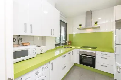 a kitchen with white cabinets and green counter tops at La Ronda - Cádiz in Jerez de la Frontera