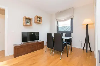a living room with a dining room table and a flat screen tv at La Ronda - Cádiz in Jerez de la Frontera