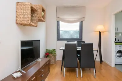 a dining room with a table and chairs and a television at La Ronda - Cádiz in Jerez de la Frontera