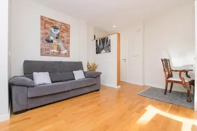 a living room with a gray couch and a wooden floor at La Ronda - Cádiz in Jerez de la Frontera
