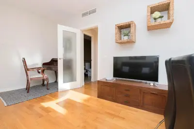 a living room with a flat screen tv on a wooden entertainment center at La Ronda - Cádiz in Jerez de la Frontera