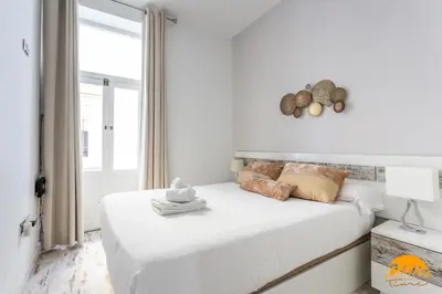 a white bedroom with a large white bed and a window at Casa Lua by Cadiz Time in Cádiz