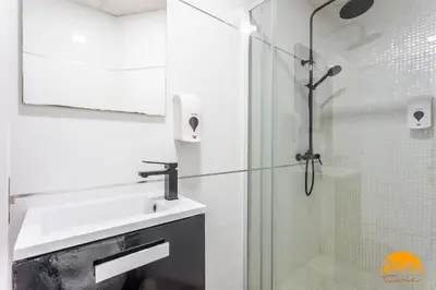 a white bathroom with a sink and a shower at Casa Lua by Cadiz Time in Cádiz