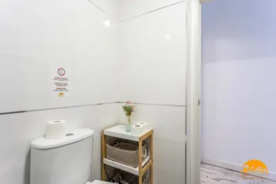 a white bathroom with a toilet and a table at Casa Lua by Cadiz Time in Cádiz