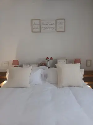 a white bed with white pillows on top of it at La Garatera in Jerez de la Frontera