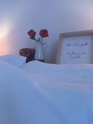 a vase with two roses in it next to a picture at La Garatera in Jerez de la Frontera