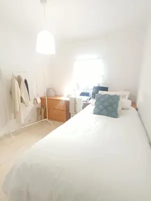 a bedroom with a white bed with a blue pillow at La Garatera in Jerez de la Frontera