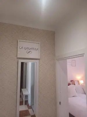 a bedroom with a bed and a sign on the wall at La Garatera in Jerez de la Frontera