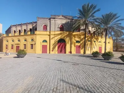 a yellow building with palm trees in front of it at La Garatera in Jerez de la Frontera