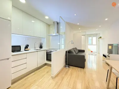 a kitchen and living room with a couch and a table at La Suite de la Laguna Grupo AC Gestion in Cádiz