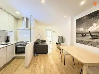 a kitchen and living room with a table and a couch at La Suite de la Laguna Grupo AC Gestion in Cádiz
