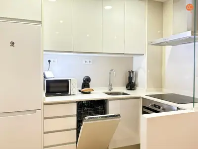 a white kitchen with a sink and a microwave at La Suite de la Laguna Grupo AC Gestion in Cádiz