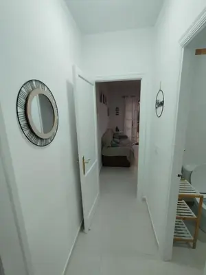 a hallway with a mirror and a room with a bed at Villa Playa in Novo Sancti Petri