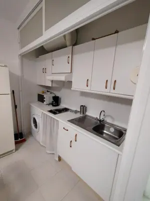a kitchen with white cabinets and a sink at Villa Playa in Novo Sancti Petri