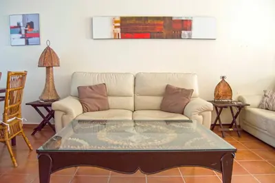 a living room with a couch and a coffee table at Casa Albatros, Apartamentos Living Sur in Sanlúcar de Barrameda